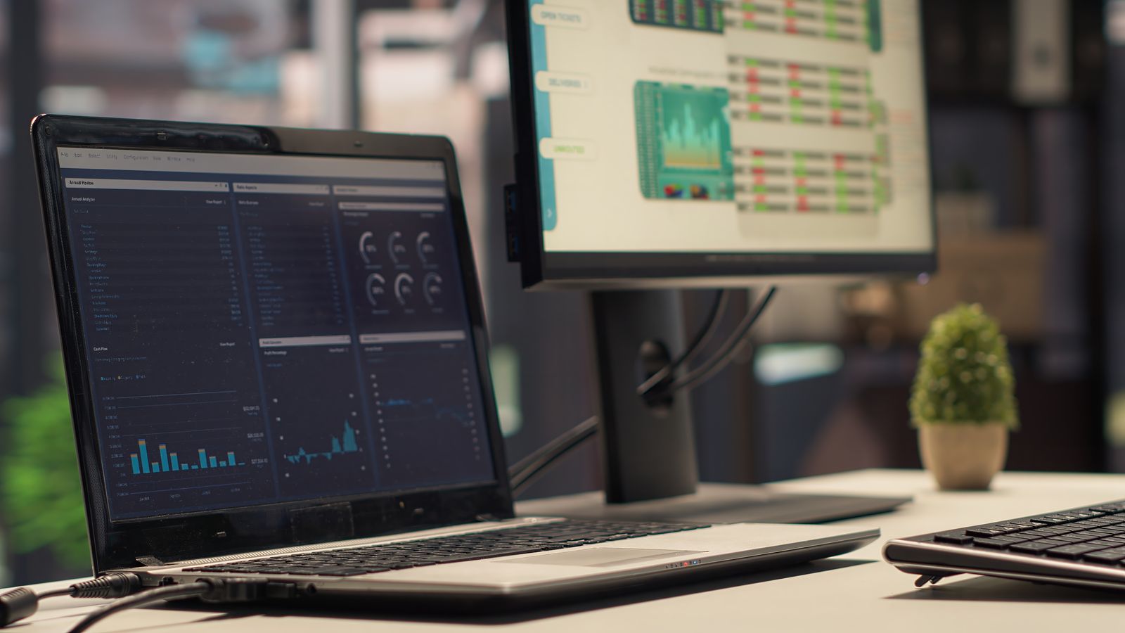 Notebook e monitor exibindo painéis de métricas de uma operação em tempo real